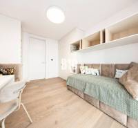 Minimalista szoba kanapéval, világos bútorokkal és fa dekorációjú padlóval egy háromszobás lakásban.