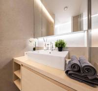 Fürdőszoba modern mosdóval, törölközőkkel és dekorációval egy háromszobás lakásban.