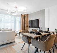 Nappali rész étkezőasztallal és fa dekoros padlóval egy háromszobás lakásban.