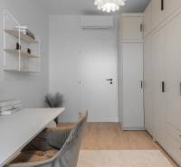 Dolgozószoba egy 3 szobás lakásban tárolóhellyel, asztallal és dekoratív elemekkel.