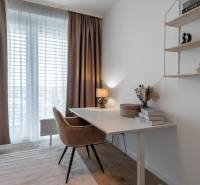 Dolgozósarok íróasztallal, kényelmes székkel és polccal egy háromszobás lakásban.