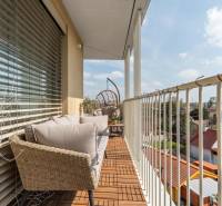 Egy háromszobás lakás erkélye Pozsonyban - Ružinovban, kültéri ülőgarnitúrával és fa dekorációval.