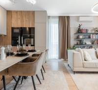 Háromszobás lakás nyitott tere konyhával, étkezőasztallal és kényelmes nappali sarokkal.