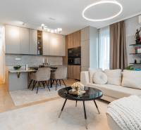 Stílusos nappali konyhával egy 3 szobás lakásban, világos árnyalatok, fa dekoros padló.