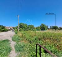 Az út a Hosťová-i telkekhez vezet, kilátással a zöldre és házakra.