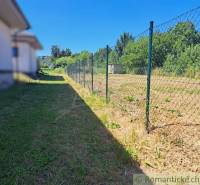 Hosťovában kerített füves telek, ideális lakhatásra.