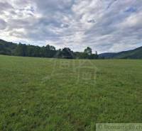 Kiterjedt zöld rét erdőkkel és dombokkal körülvéve Felsőtisovník környékén, Lakóterületek.