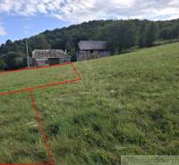 Földterületek - lakóterület, Felső Tiszovnik. Füves terület vidéki épülettel és erdős dombbal a háttérben.