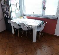 Két szobás lakás konyhája étkezőasztallal, fehér székekkel és ablakkal.