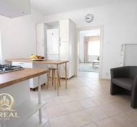 Konyha bárpulttal az egyszobás lakásban és gyümölcs az asztalon.