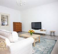 Nappali televízióval, kanapéval és dohányzóasztallal egy egyszobás lakásban.