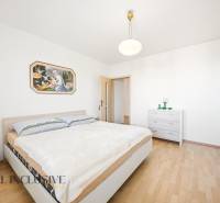 Hálószoba fa dekor padlóval egy családi házban és egy képpel a falon.