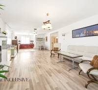 Nappali egy családi házban, fa dekorációjú padlóval és világos bútorokkal.