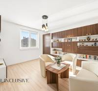 Nappali családi házban fehér fotelekkel és fa mintázatú padlóval.