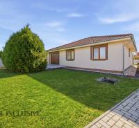 Családi ház Kútnikokban gyeppel, fákkal és térkövekkel.