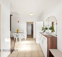 Családi ház belső tere fehér asztallal és székekkel, nagy tükörrel a falon.