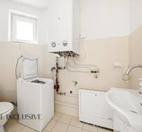 Fürdőszoba családi házban tartállyal, mosógéppel és mosdóval.