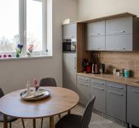 Irodai konyhasarok ablakos, fa dekorációval és étkezőasztallal.