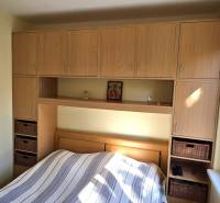 Hálószoba finom falakkal és tárolóhellyel egy háromszobás lakásban.