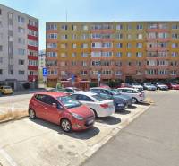 Parkoló a pozsonyi - račai lakóházak előtt színes homlokzatokkal.