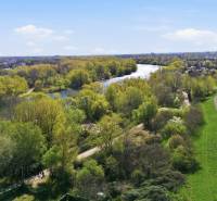 Kilátás a kertekre Vághosszúfalu (Királyfa) területén, a folyóval és gazdag zöld növényzettel.