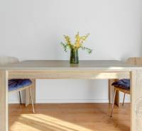 Étkezőasztal virágvázával a padlón, fa dekorációval a kétszobás lakásban.