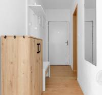 Előszoba egy kétszobás lakásban szekrénnyel és fa dekorációjú padlóval.