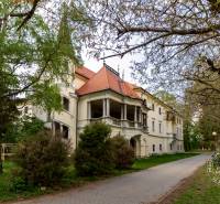 Történelmi épület fákkal körülvéve a Vincent Šikula utcában, Stupaván.