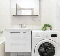 Fürdőszoba káddal, mosdóval és mosógéppel egy kétszobás lakásban.