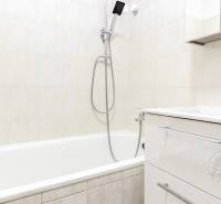 Fürdőszoba fehér káddal és mosdóval egy kétszobás lakásban.