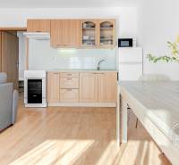 Konyha egy kétszobás lakásban, fa dekoros padlóval és étkezőasztallal.