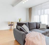 Világos nappali fa mintázatú padlóval, kényelmes kanapéval és étkezősarokkal.