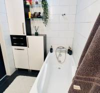 Fürdőszoba káddal, szekrényekkel és dekorációkkal egy háromszobás lakásban.