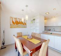 Étkezőhelyiség faasztallal és dekoratív művészettel egy kétszobás lakásban.