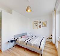 Hálószoba egy kétszobás lakásban ággyal, éjjeliszekrénnyel és fa dekoros padlóval.