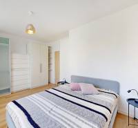 Hálószoba egy kétszobás lakásban ággyal, szekrényekkel és fa dekorációjú padlóval.