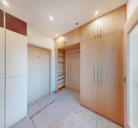 Beépített szekrények és csempézett padló egy kétszobás lakásban világos bútorokkal.