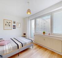 Világos hálószoba egy kétszobás lakásban, dekorációkkal a fehér falon.