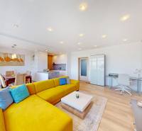 Világos nappali tér élénksárga kanapéval, étkező sarokkal és fa dekorációjú padlóval.