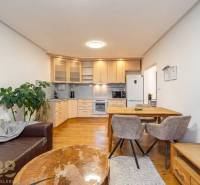 Nappali konyhasarokkal egy üdülő apartmanban, fa dekorációjú padlóval.