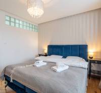 Hálószoba üdülő apartmanban franciaággyal és fa dekorációjú padlóval.