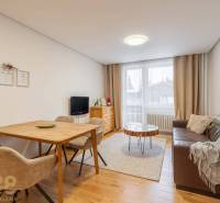 Nappali egy nyaraló apartmanban, hangulatos kanapéval és fa dekorációjú padlóval.