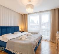 Nyaraló apartman hálószobája kényelmes ággyal és fa dekorációjú padlóval.