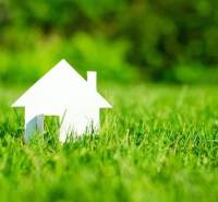 Fehér házmodell zöld fűvön Tešedíkovo-ban, telkek - lakóövezet.