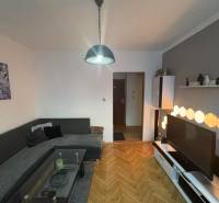 Nappali fa mintás padlóval és világítással egy kétszobás lakásban.