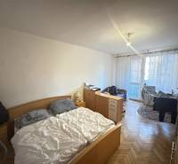 Hálószoba egy kétszobás lakásban bútor garnitúrával és fa dekor padlóval.