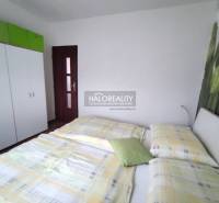 Hálószoba egy 4 szobás lakásban ággyal, szekrénnyel és virágos dekoratív fallal.