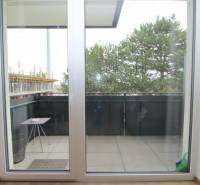 Erkély tolóajtókkal és kilátással a fákra egy egyszobás lakásban a Broskyňová utcában, Rovinkában.