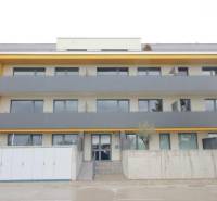 Lakóház a Rovinka-i Broskyňová utcában, sárga elemekkel a homlokzaton.