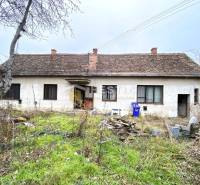Egy régi családi ház felújításra vár, a kertben vad növényzet és rendetlenség van.